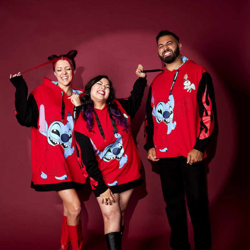 Two women and one man stand and laugh together wearing the Devil Stitch Unisex Hoodie